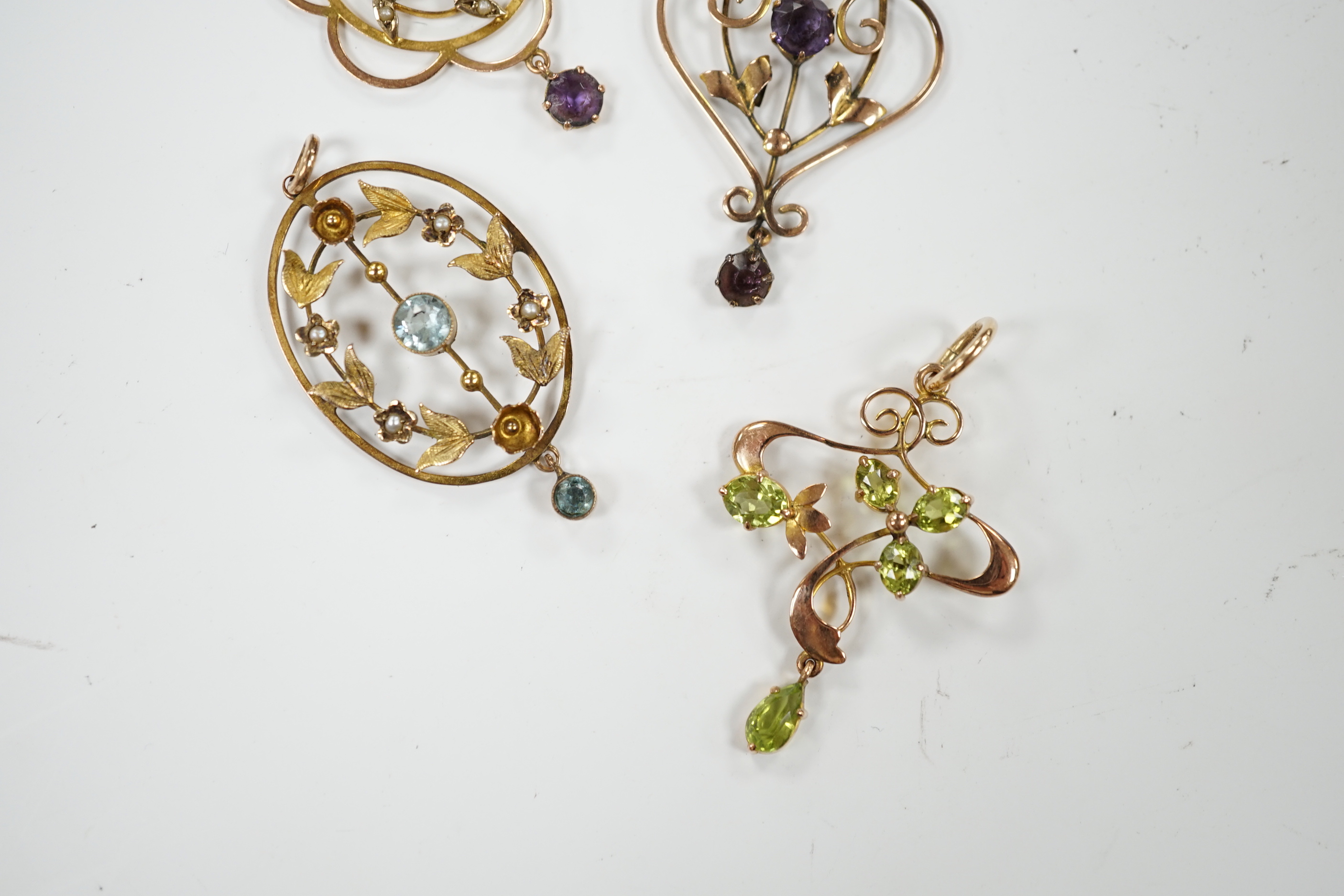 Three assorted early 20th century 9ct and gem set pendants, one other similar yellow metal and gem set pendant, largest, 40mm, gross weight 7.5 grams.